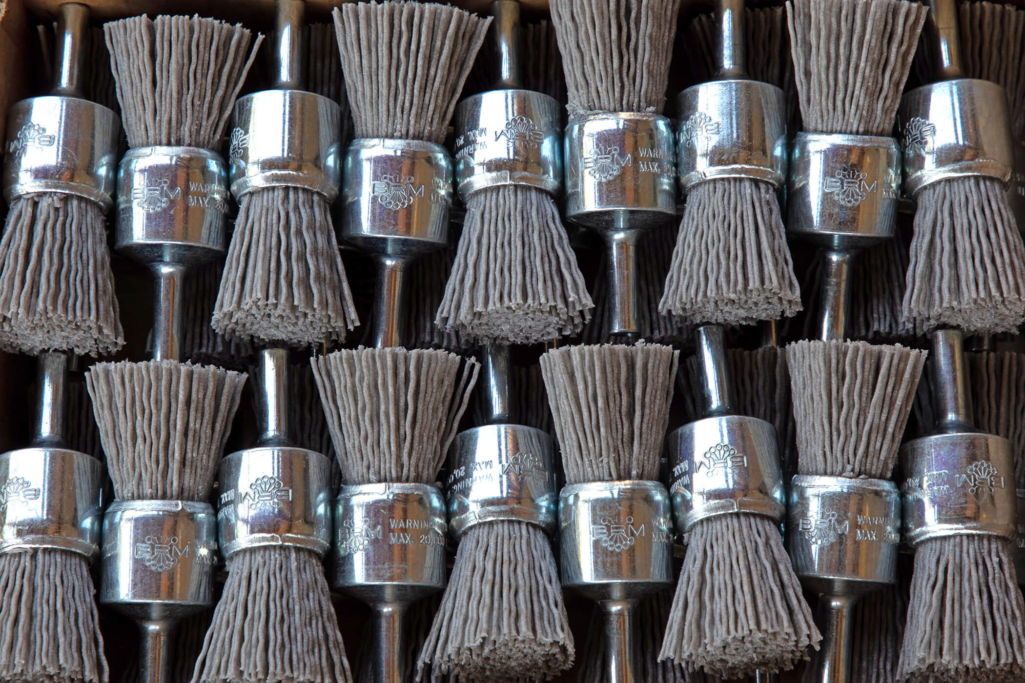 Collection of abrasive nylon end brushes with bristle heads arranged in a grid.